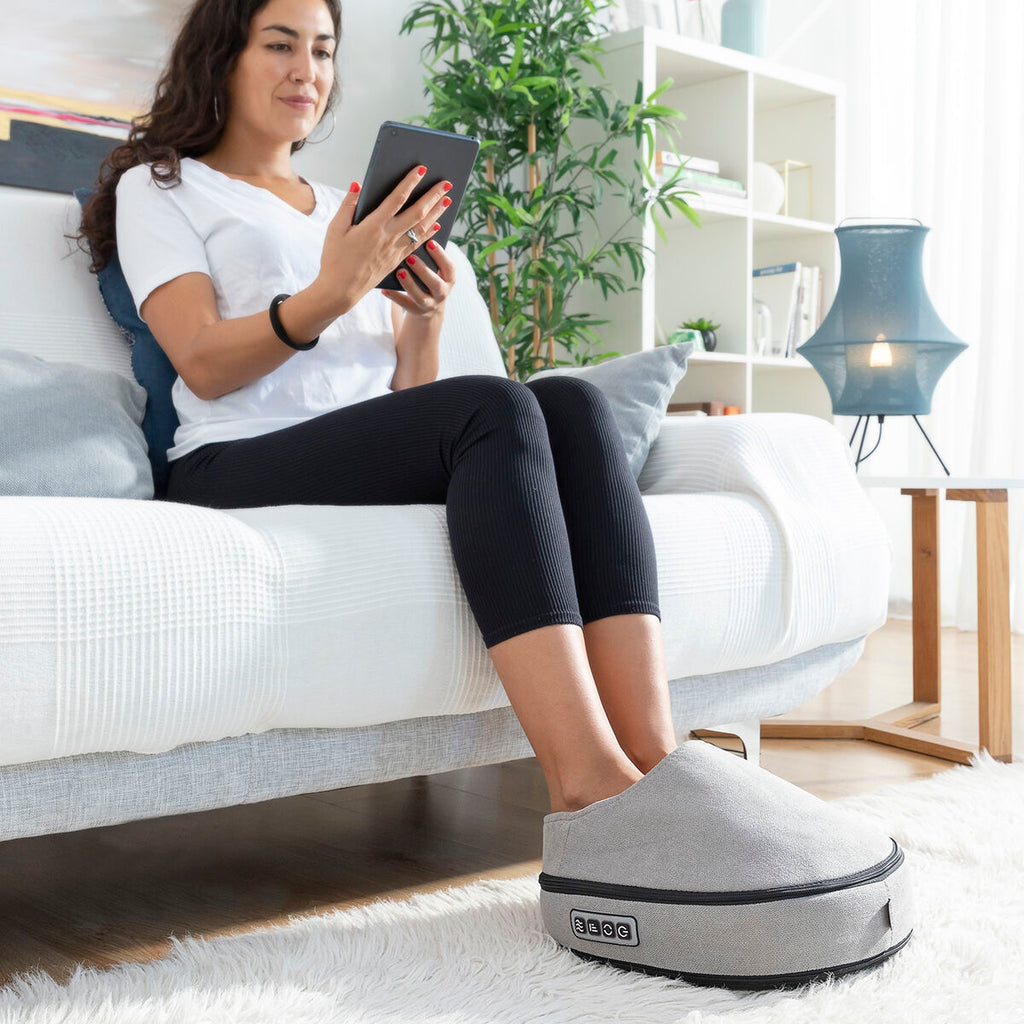 Kvinna använder 2-i-1 shiatsu fotmassager på soffa