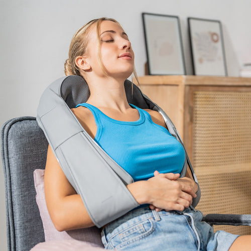 Kvinna som använder shiatsu-massageapparaten runt nacken och axlarna